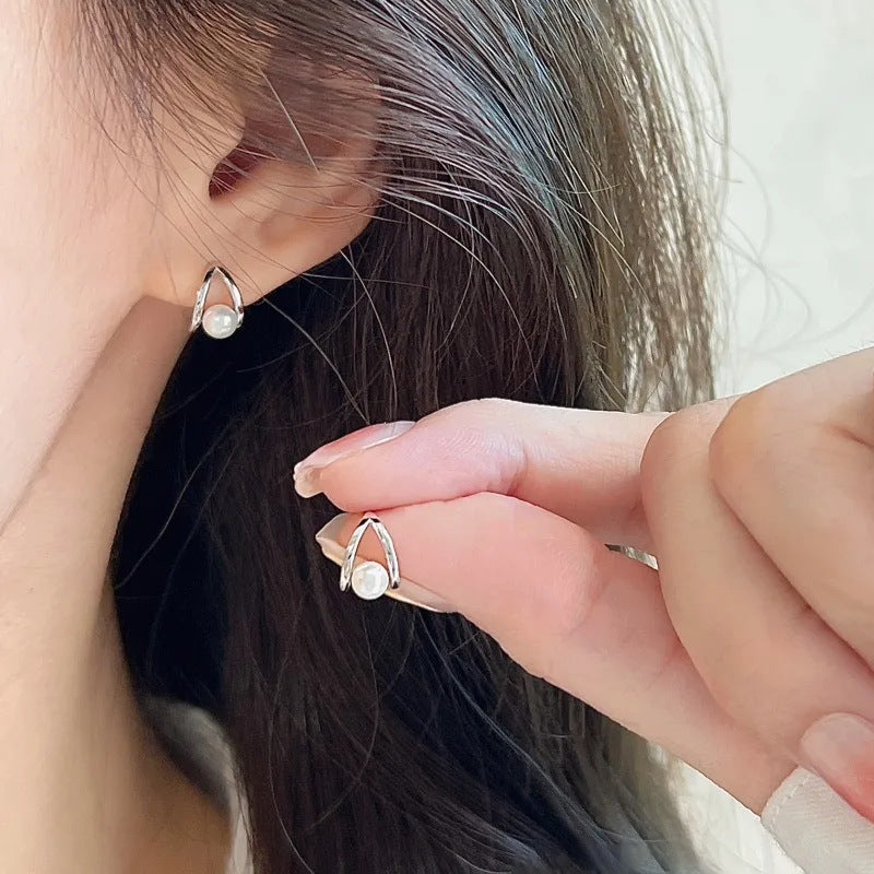 Close-up of pearl teardrop stud earring on stud post