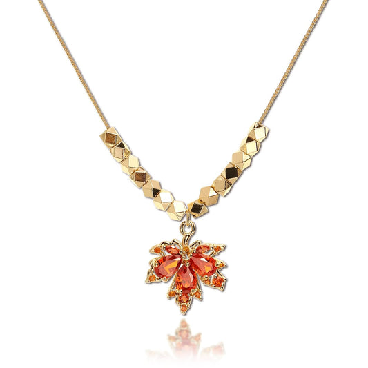 Close-up of Maple Leaf Necklace with orange crystal drop on 14K gold-plated brass