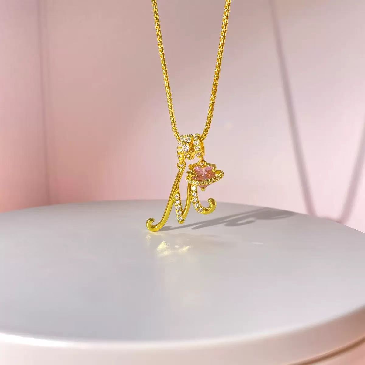 Close-up of gold initial necklace A pendant and fine chain