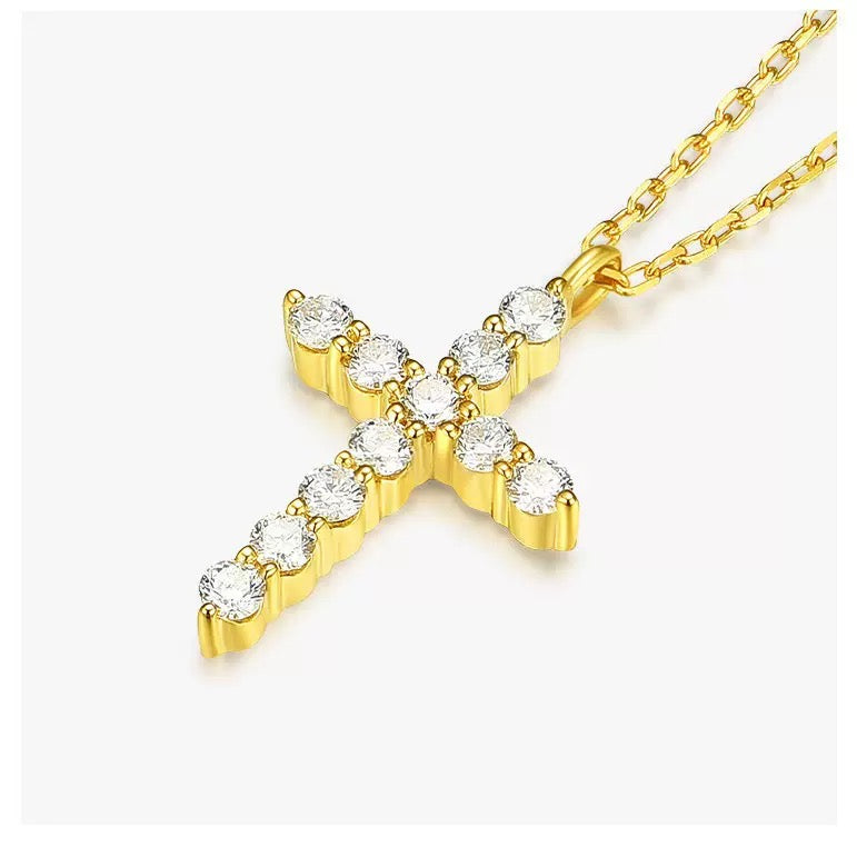 Close-up of 14K gold cross pendant with polished finish