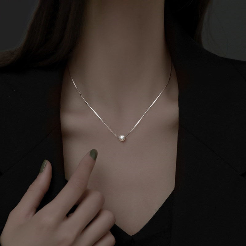 Model wearing Eternal Pearl Necklace, side view highlighting design