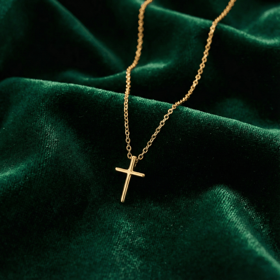 Close-up of minimalist gold cross pendant showing smooth polished finish and clean design