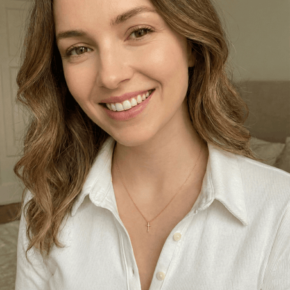 Model wearing minimalist gold cross pendant necklace for everyday elegant styling